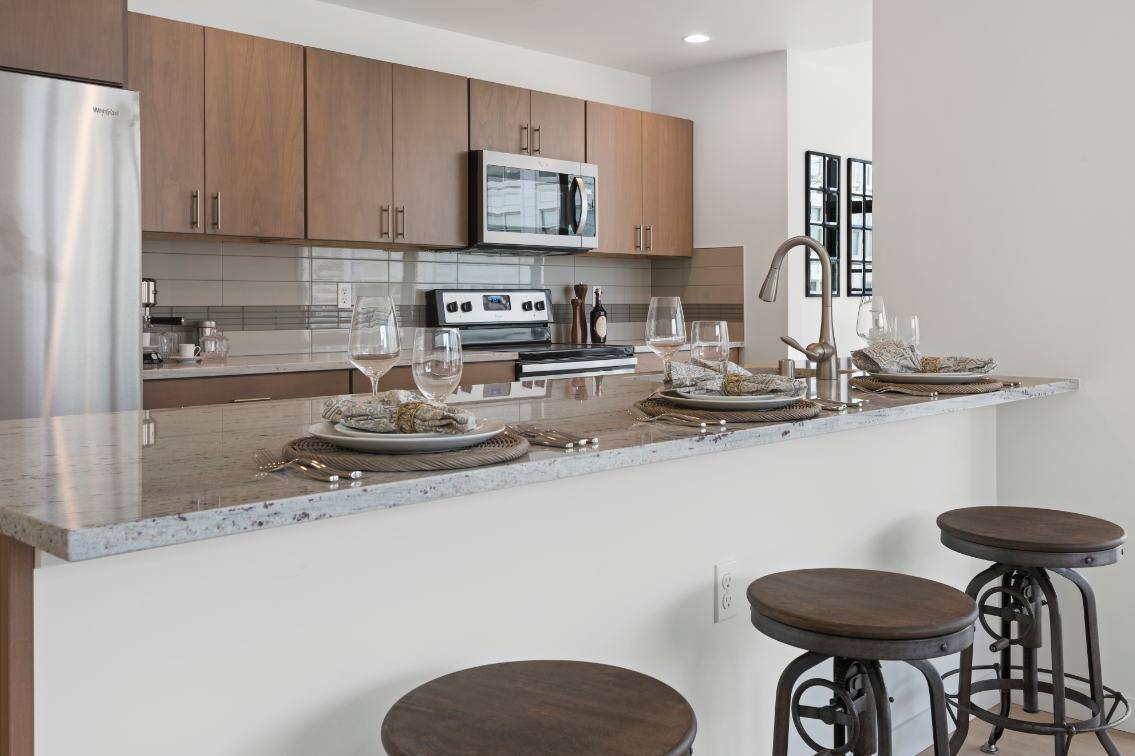 A kitchen with a marble countertop and a microwave above it.